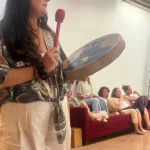 Alicia Dallery, thérapeute holistique à Montélimar, jouant du tambour chamanique lors d'un atelier de soins énergétiques